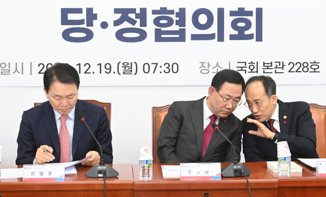 윤석열 정부 2023년 경제정책방향을 논의하기 위해 19일 오전 서울 여의도 국회에서 열린 당·정협의회에 참석한 주호영(가운데) 국민의힘 원내대표와 추경호(오른쪽) 부총리 겸 기획재정부 장관이 성일종(왼쪽) 정책위의장이 자료를 살펴보는 사이에 대화를 나누고 있다.  김동훈 기자
