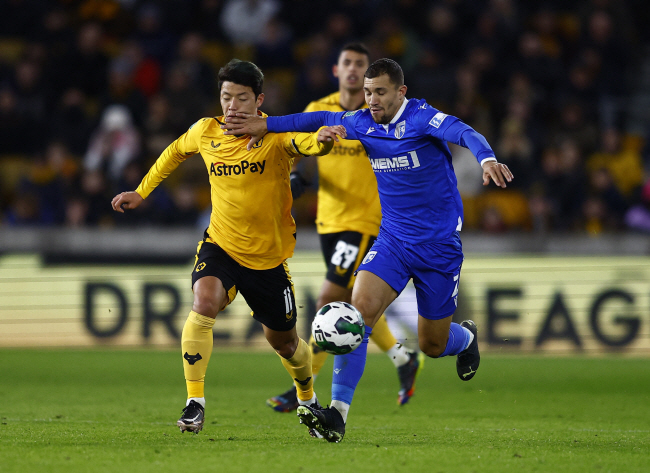 울버햄프턴 원더러스의 황희찬(왼쪽)이 21일 오전(한국시간) 영국 울버햄프턴의 몰리뉴 스타디움에서 열린 질링엄과의 카라바오컵 16강전에서 수비와 공 다툼을 벌이고 있다. 로이터 연합뉴스