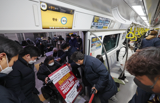 전국장애인차별철폐연대 회원들이 19일 오전 서울 지하철 노량진역에서 지하철 탑승 시위 중 무정차 통과 조치를 규탄하며 기습시위를 하고 있다. 연합뉴스