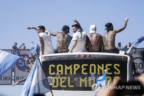 (부에노스아이레스 AP=연합뉴스) 아르헨티나 수도 부에노스아이레스 도심에서 20일(현지시간) 진행된 월드컵 우승 축하 카퍼레이드에서 리오넬 메시(맨 가운데)를 비롯한 아르헨티나 축구 대표팀이 손을 흔들며 팬들에게 인사하고 있다. 이날 카퍼레이드 행사장에는 많은 축구 팬들이 몰려들어 인산인해를 이뤘다.