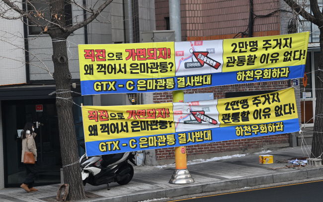 26일 오전 서울 용산구 한남동 유엔빌리지 입구 도로에 GTX-C 은마아파트 관통 반대 현수막이 걸려 있다.   김호웅 기자