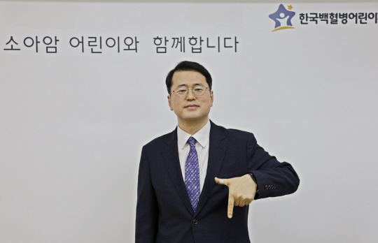 서선원 한국백혈병어린이재단 사무총장이 왼손으로 숫자 7을 그리는‘럭키칠곡 포즈’로 기념 촬영을 하고 있다. 칠곡군청 제공