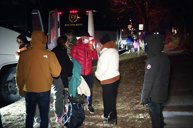 지난 24일 역대급 겨울 ‘폭풍 사이클론’이 미국 북동부를 덮친 가운데, 불법으로 국경을 넘은 것으로 추정되는 이민자들이 워싱턴DC의 카멀라 해리스 부통령 자택 인근에서 교회로 이송되는 버스에 올라타고 있다. 이들은 조 바이든 행정부의 이민정책에 항의하는 공화당 소속 그레그 애벗 텍사스 주지사에 의해 텍사스주에서 이곳까지 이송됐다.   AP 연합뉴스