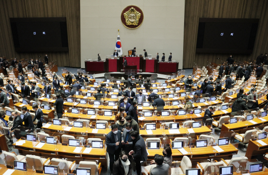 지난해 12월 24일 새벽 2023년도 정부 예산안 통과 뒤 산회가 선포되자 여야 의원들이 국회 본회의장을 나서고 있다. 연합뉴스