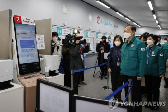 한덕수 국무총리가 2일 인천국제공항의 중국발 입국자 유전자증폭(PCR) 검사 현장과 대기 장소를 방문해 현황을 보고 받고 현장을 점검하고 있다. 연합뉴스