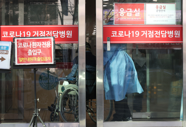 코로나19 위중증 환자가 600명대에서 줄지 않고 있는 가운데 2일 코로나19 거점병원인 서울 광진구 혜민병원에 확진자가 휠체어를 타고 들어서고 있다. 연합뉴스