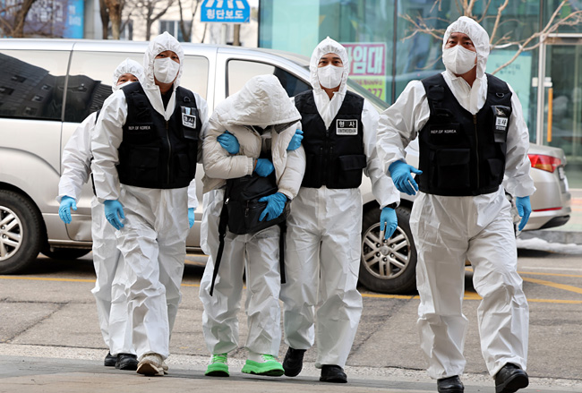 인천국제공항 입국과정에서 코로나19 확진 판정 후 호텔 격리를 거부하고 도주했던 40대 중국인 A 씨(가운데)가 5일 서울에서 검거돼 인천시 중구 모 호텔로 압송되고 있다. 연합뉴스