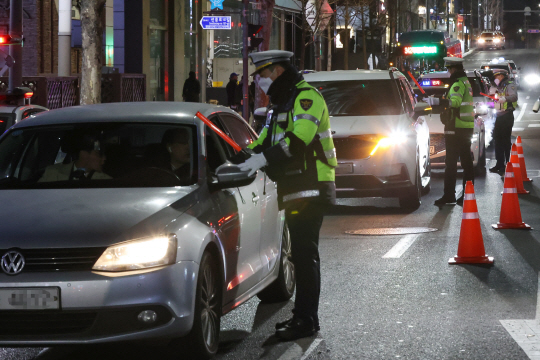 경찰이 ‘연말·연시 특별 음주 단속’을 벌이고 있는 가운데, 4일 밤 서울 강남구 압구정로데오역 인근 도로에서 경찰관이 음주 의심 운전자 등에 대해 검문을 벌이고 있다. 연합뉴스