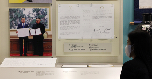 세종시 어진동 대통령기록관을 찾은 관람객이 윤석열 정부가 9·19 군사합의 효력정지 검토에 들어간 4일 문재인 전 대통령과 김정은 국무위원장의 2018년 9월 19일 평양공동선언 기념촬영 사진을 살펴보고 있다.  연합뉴스
