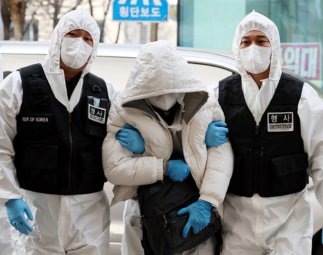 인천국제공항 입국과정에서 코로나19 확진 판정 후 호텔 격리를 거부하고 도주했던 40대 중국인 A 씨(가운데)가 5일 서울에서 검거돼 인천시 중구 모 호텔로 압송되고 있다. 연합뉴스