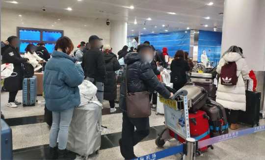5일 오후 중국 랴오닝성 다롄 국제공항에서 한국발 입국자들이 입국 수속을 마친 뒤 시설 격리 여부에 대한 안내를 기다리고 있다. 연합뉴스