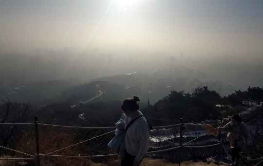 8일 오전 서울 종로구 인왕산에서 등산하는 시민들 너머로 미세먼지로 인해 뿌연 도심이 보인다.