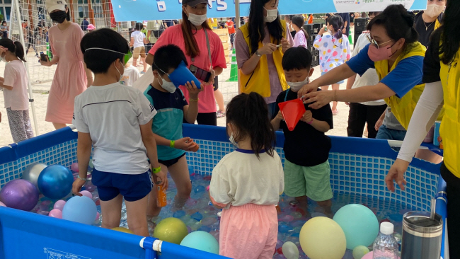 경남 창원 신항초에서 지난해 8월 27일 열린 ‘요요!놀이터’ 첫째 날, 물놀이터를 테마로 마련된 워터 슬라이드(맨 위), 박 터트리기(가운데), , 꼬꼬닭 게임(아래) 등 여러 코너에 아이들이 참여하며 즐거워하고 있다.   초록우산어린이재단 제공