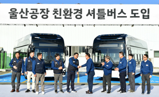 현대자동차 이동석(왼쪽 여섯번째) 대표이사와 안현호(왼쪽 다섯번째) 노조위원장이 12일 울산공장에서 ‘친환경 셔틀버스’ 도입을 위한 기념 행사를 가진뒤 악수를 나누고 있다. 현대자동차 제공
