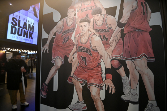 영화관을 찾은 시민이 슬램덩크 홍보물 앞에서 기념촬영을 하고 있다. 3040 남성 관객들의 향수를 자극하며 흥행하고 있다. 문호남 기자