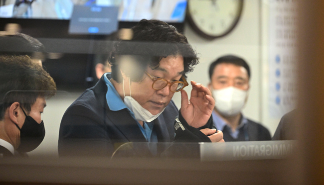 김성태 전 쌍방울 그룹 회장이 지난 17일 인천국제공항에 도착해 입국심사대를 지나며 안경을 고쳐 쓰고 있다. 김동훈 기자