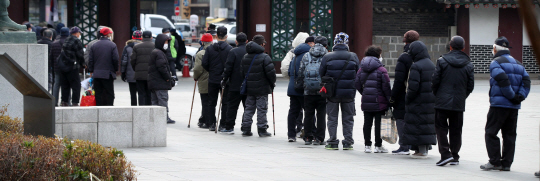 설 명절 연휴를 이틀 앞둔 19일 서울 종로구 탑골공원에서 노인들이 인근 무료급식소에서 점심 배식을 받기 위해 줄을 서고 있다. 뉴시스