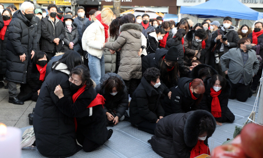 설날인 22일 서울 용산구 녹사평역 인근에 마련된 이태원 참사 희생자 합동분향소에서 열린 합동 차례에서 유가족들이 희생자들에게 큰 절을 올리다가 부둥켜안고 오열하고 있다.  뉴시스