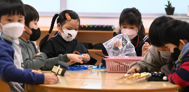 실내 마스크 착용 의무 해제를 사흘 앞둔 27일 오전 서울 종로구 세검정유치원에서 원아들이 마스크를 쓰고 놀이학습을 하고 있다. 이 유치원은 실내마스크 착용 의무 해제 이후에도 당분간 마스크를 착용하도록 할 예정이다.    윤성호 기자
