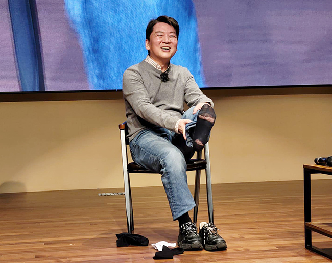 안철수 국민의힘 의원이 29일 오후 경기 양주시 경기섬유종합지원센터에서 열린 ‘수도권 청년들의 미래를 위한 토크콘서트’에서 청년 당원이 선물한 양말로 갈아 신기 위해 신고 있던 해진 양말을 들어보이고 있다. 안철수 의원 페이스북 갈무리.