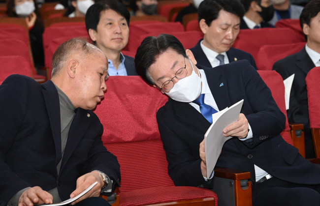 ‘대장동·위례 개발 특혜 의혹’ 2차 검찰 소환 조사를 앞둔 이재명(오른쪽) 더불어민주당 대표가 31일 오전 국회 의원회관에서 열린 부실 미분양 주택 매입임대 전환 토론회에 참석해 이용우 민주당 의원과 이야기를 나누고 있다. 김동훈 기자