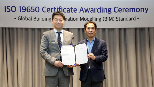 김영신(오른쪽) GS건설 전무와 임성환 BSI 코리아 대표이사가 지난 1일 서울 종로구 GS건설 본사에서 열린 ISO 19650 인증서 수여식에서 기념촬영을 하고 있다. GS건설 제공