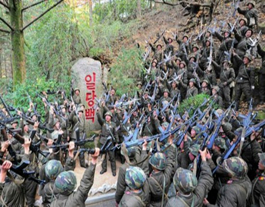 오는 8일 북한의 인민군 창건일(건군절) 75주년을 앞두고 있는 가운데 북한 대외선전매체 ‘우리민족끼리’는 6일 김일성 주석이 ‘일당백’ 구호를 제시한지 60주년이 됐다고 선전했다. 사진은 북한 인민군이 일당백 문구를 둘러싸고 함성을 지르는 모습. 연합뉴스·우리민족끼리 홈페이지 캡처.