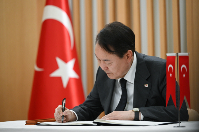 윤석열 대통령이 9일 서울 중구 주한 튀르키예 대사관을 방문해 지진 피해 희생자들을 애도한 뒤 조문록을 작성하고 있다.  대통령실 제공