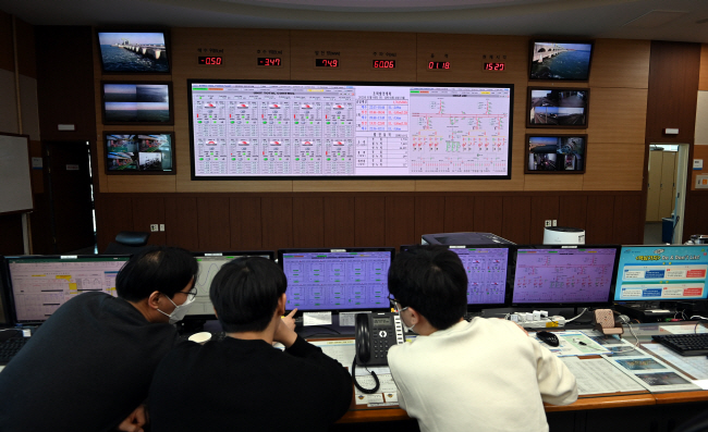 지난 8일 경기 안산시 시화조력발전소 내 제어실에서 직원들이 실시간으로 업데이트되는 서해와 시화호 간 낙차, 발전량, 발전 스케줄 등의 자료를 확인하고 있다.   박윤슬 기자