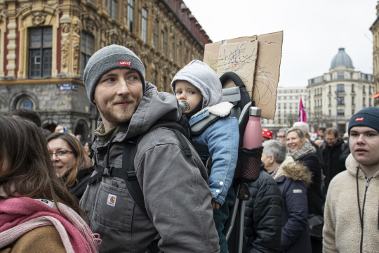 11일(현지시간) 프랑스 북부지역 릴에서 열린 연금개혁 반대 집회에 한 시위자가 아이를 업은 채 참가하고 있다. 신화·연합뉴스