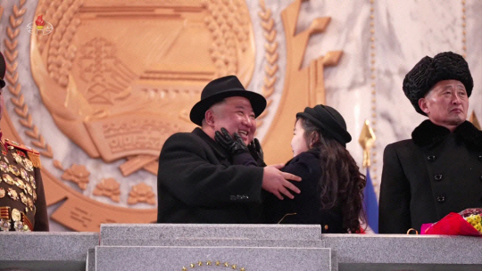 지난 8일 평양 김일성광장에서 북한 인민군 창건일(건군절) 75주년 야간 열병식이 실시된 가운데 주석단에서 이를 참관하던 김정은 국무위원장의 딸 김주애가 김 위원장의 볼을 스다듬고 있다. 연합뉴스