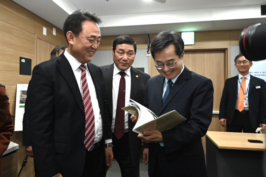 지난 16일 경기 수원시 경기도청사에서 김동연(왼쪽 세번 째) 경기지사와 이충우(왼쪽 첫 번째) 여주시장이 ‘K-배터리 제조시설 건립 및 이차전지 혁신생태계 기반 조성을 위한 투자유치 양해각서’ 체결을 위한 문건을 살피며 웃고 있다. 여주시청 제공