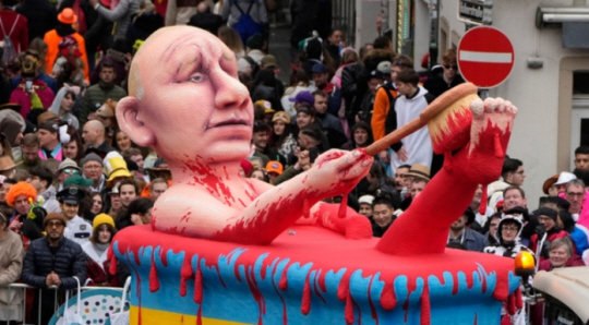 20일 독일 뒤셀도르프에서 전통 카니발 퍼레이드가 열려 블라디미르 푸틴 러시아 대통령이 피로 목욕하는 모습을 나타낸 조형물이 행진하고 있다. AP 뉴시스