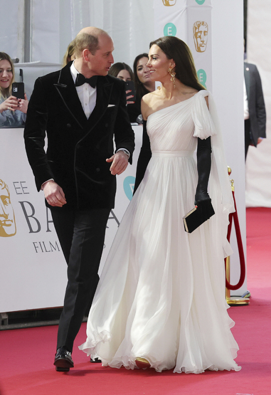 19일 BAFTA에 참석한 윌리엄 왕세자(왼쪽)와 캐서린 왕세자빈이 레드 카펫 위를 걸으며 대화를 나누고 있다. AP 연합뉴스