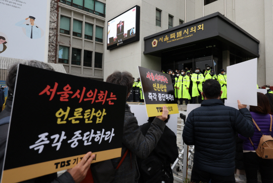 지난해 11월 15일 오후 서울시의회 본회의장에서 서울특별시 미디어재단 TBS 설립 및 운영에 관한 조례 폐지조례안 등 안건에 대한 회의가 진행 중인 가운데 TBS 구성원들이 피켓 시위를 하고 있다. 연합뉴스