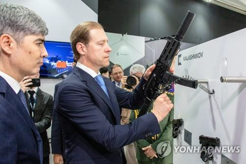 데니스 만투로프(가운데) 러시아 산업통상부 장관이 20일(현지시간) UAE IDEX 행사장을 찾아 총을 들어보고 있다.타스／연합뉴스
