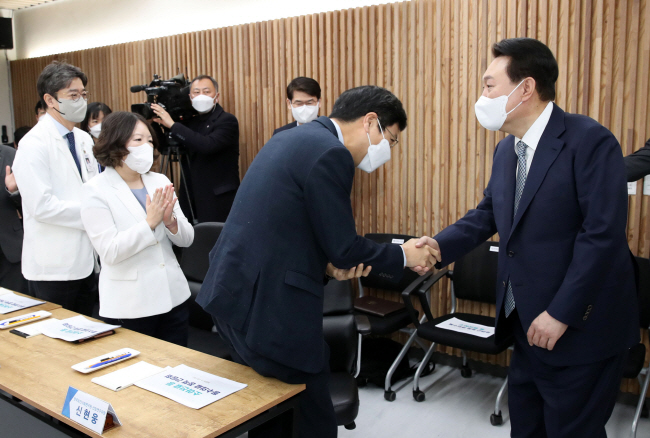 윤석열 대통령이 22일 오전 서울 종로구 서울대학교어린이병원에서 열린 소아진료 등 필수의료 정책간담회에 입장해 참석자들과 악수하고 있다.  연합뉴스