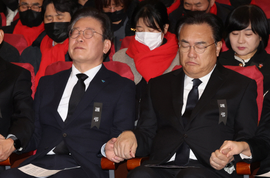 이재명(왼쪽) 더불어민주당 대표와 정진석 국민의힘 비상대책위원장이 지난 5일 국회 의원회관 대회의실에서 열린 10.29 핼러윈 참사 국회추모제에서 기독교 추모의례에 맞춰 손을 잡고 기도하고 있다. 뉴시스