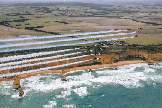 공군 특수비행팀 블랙이글스(Black Eagles, 뒤쪽 편대)가 27일(현지시간) 호주 공군 특수비행팀 룰렛(Roulettes)과 호주 빅토리아주 지역 명소인 ‘12사도 바위(Twelve Apostles)’ 상공으로 우정 비행을 펼치고 있다. 공군 제공
