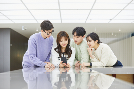 현대오일뱅크 직원들이 경기 성남시 HD현대 신사옥에서 스마트폰으로 ‘블루톡’을 보며 휴식을 취하고 있다. 현대오일뱅크 제공