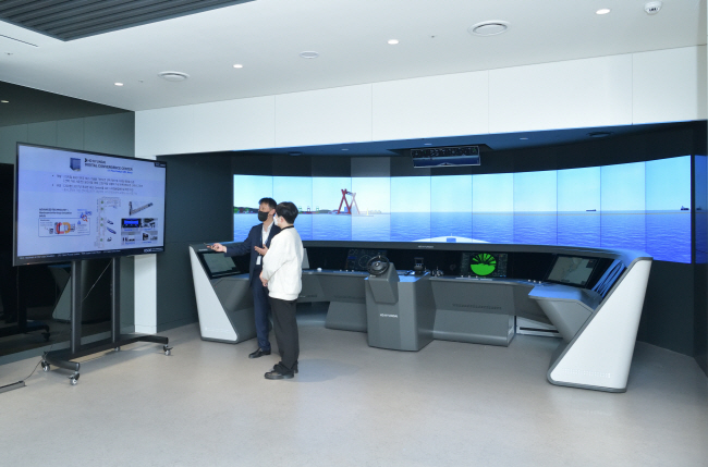 경기 성남시 판교 HD현대 글로벌연구개발센터(GRC) 6층에 위치한 디지털융합센터에서 류승협(왼쪽) 한국조선해양 디지털연구랩 상무가 디지털 트윈을 활용한 사이버 시운전에 대해 설명하고 있다.  HD현대 제공