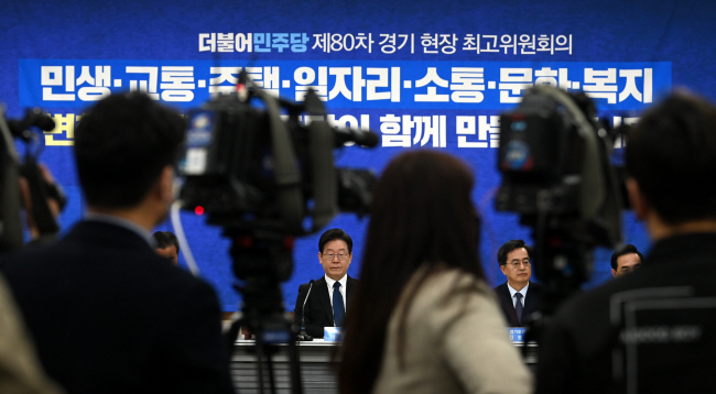 10일 오전 경기 수원시 경기도의회에서 열린 현장 최고위원회의에 참석해 굳은 표정으로 앉아있는 이재명(가운데) 더불어민주당 대표의 모습이 취재진 사이로 보이고 있다. 윤성호 기자