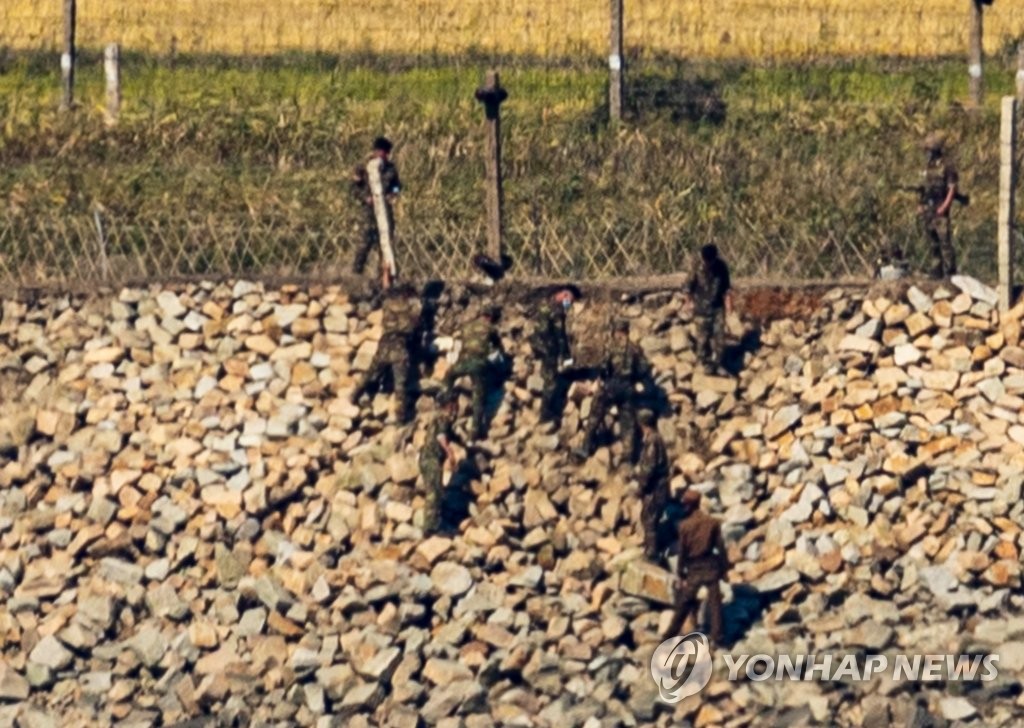 지난해 10월 인천시 강화군 평화전망대에서 바라본 북한 황해도 개풍군의 철책에서 북한군 초병들이 마스크를 쓰고 둑과 철책 보수작업을 하고 있다. 연합뉴스