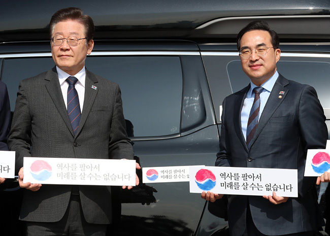 이재명(왼쪽) 더불어민주당 대표, 박홍근 원내대표가 22일 서울 영등포구 국회 본청 앞에서 열린 대일굴종외교 규탄 태극기 달기 운동 행사에서 차량에 태극기 스티커를 붙인 후 기념촬영을 하고 있다. 뉴시스