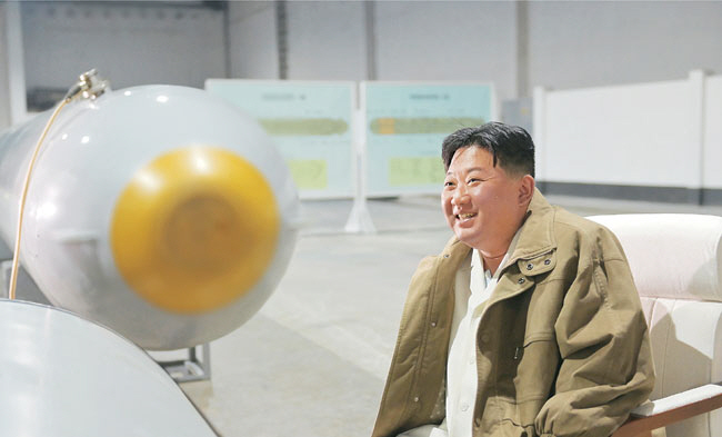 김정은 북한 국무위원장이 21∼23일 수중폭발 시험을 한 핵무인수중공격정 모형을 살펴보며 웃고 있는 모습을 조선중앙통신이 24일 보도했다. 김 위원장 뒤로 핵무인수중공격정 설계도도 보인다. 연합뉴스