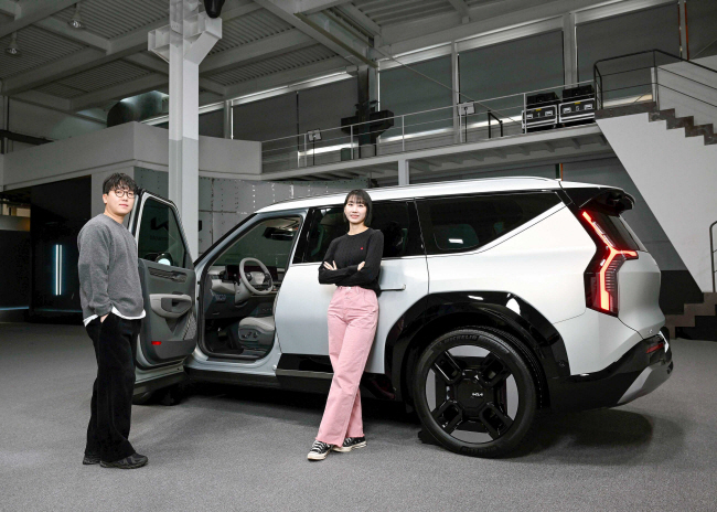 EV9 인테리어 디자인 개발을 담당한 천보람(왼쪽) 기아글로벌디자인센터 기아넥스트디자인내장팀 책임연구원과 전태운 연구원이 EV9 옆에서 포즈를 취하고 있다. 기아 제공