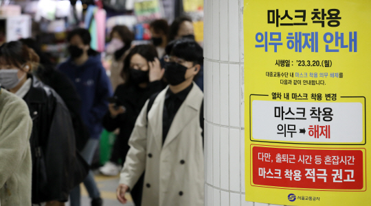 대중교통 내 마스크 착용 의무 해제 이틀째였던 지난 21일 오전 서울 구로구 지하철 신도림역에서 마스크 착용 의무 해제 안내문 옆으로 마스크를 착용한 이용객들이 지나다니고 있다. 뉴시스