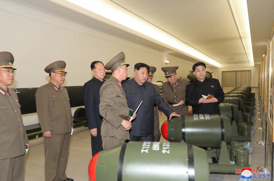 조선중앙통신은 28일 김정은 국무위원장이 핵무기병기화사업을 지도하고 핵반격작전계획과 명령서를 검토했다고 보도했다. 이날 통신이 공개한 사진에서 김 위원장 주변으로 핵탄두 모형과 설명표지판이 드러나 있다. 연합뉴스·조선중앙통신