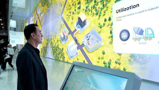 명성 SK어스온 사장이 지난 1월 미국 라스베이거스에서 열린 소비자가전쇼(CES) 2023의 SK 전시관에서 ‘탄소 솔루션 제공자(Carbon Solution Provider)’ 전략을 설명해 놓은 탄소 포집·저장(CCS) 관련 영상을 보고 있다. SK어스온 제공