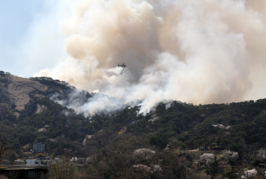 2일 오후 산불이 발생한 서울 종로구 인왕산에서 소방헬기가 진화 작업을 하고 있다. 연합뉴스